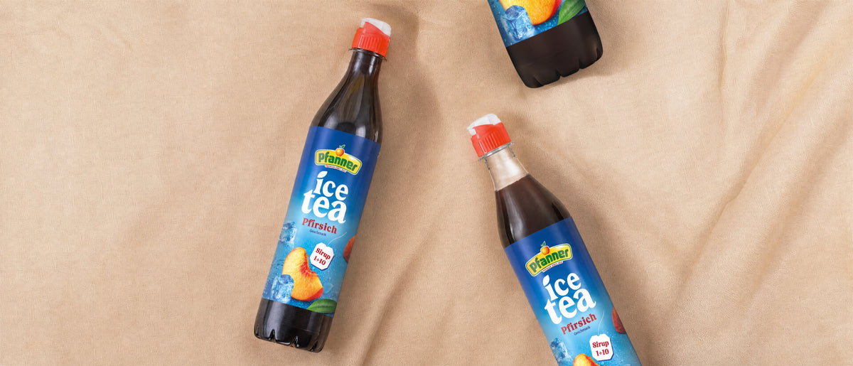 Flaschen Pfanner Ice Tea Sirup Pfirsich auf beigem Stoff
